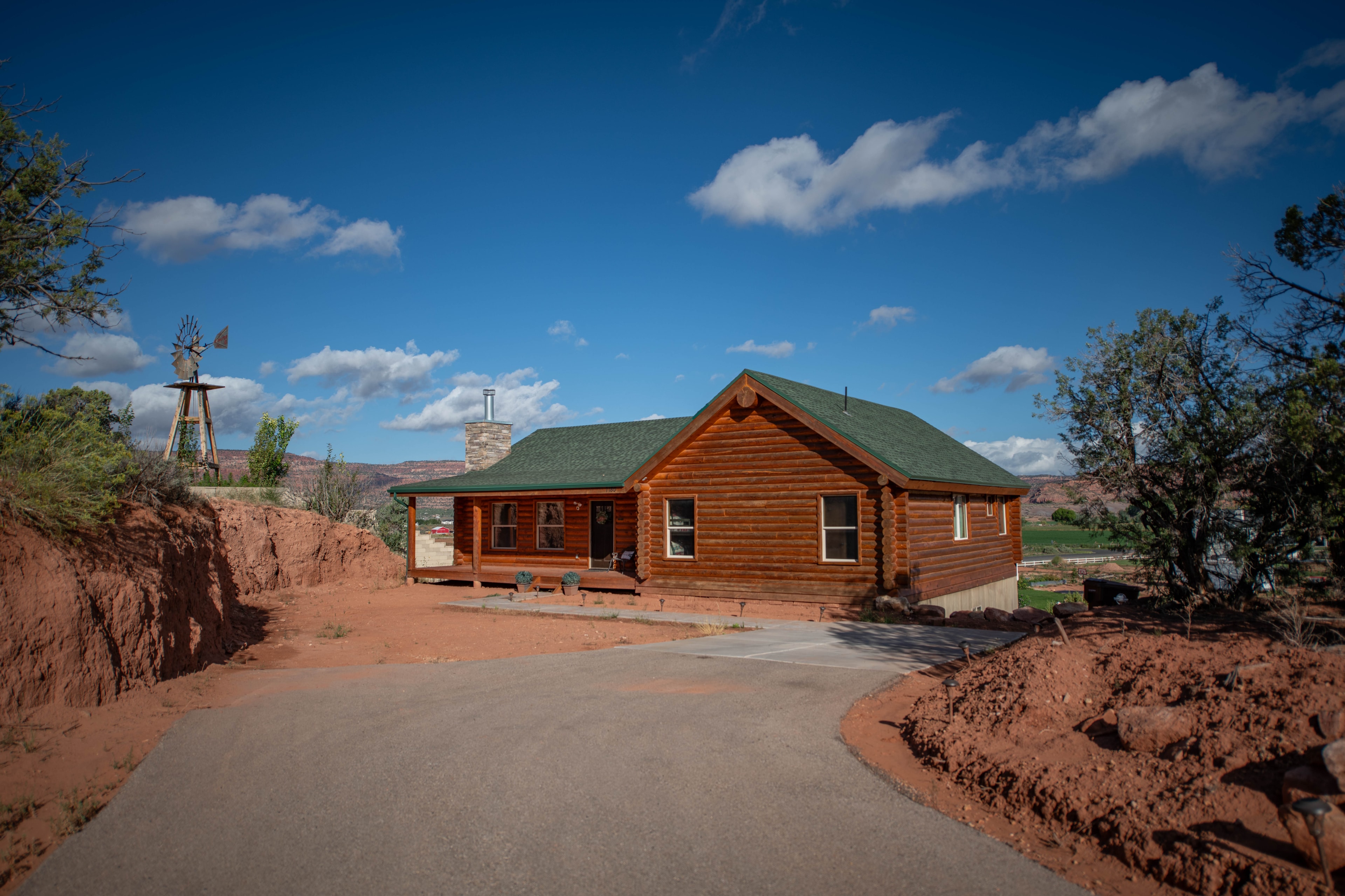 Aerial drone — log cabin ranch with windmill and desert landscape, Kanab