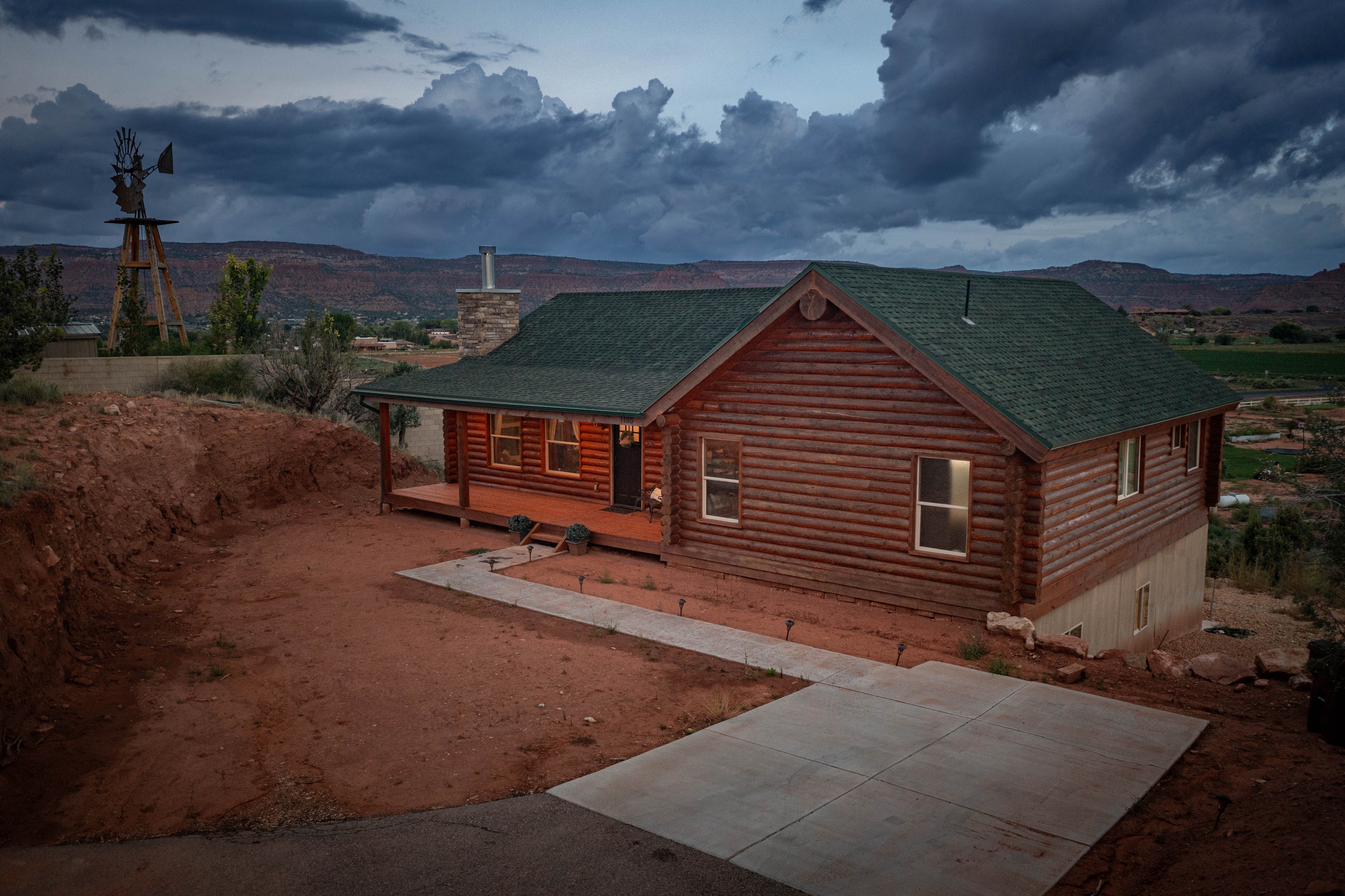 Aerial drone — red log cabin desert landscape with windmill, Southern Utah