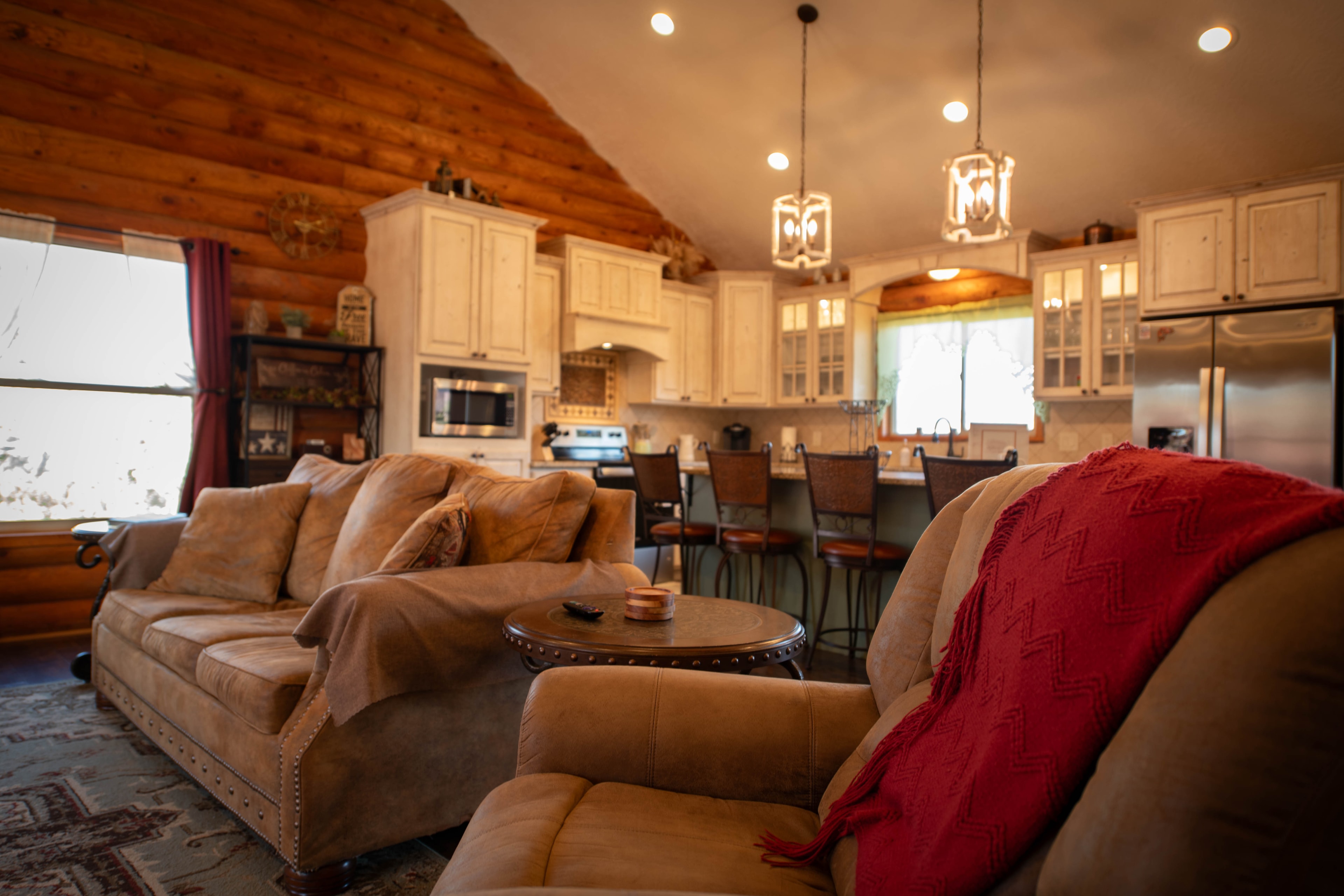 Open-plan log cabin great room with vaulted ceiling and pendant lights — Kanab